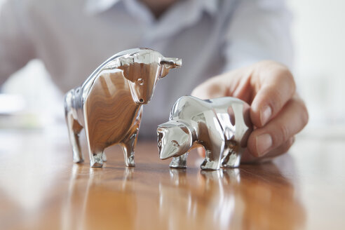 Miniaturskulpturen von Stier und Bär auf einem Schreibtisch - RBF002439