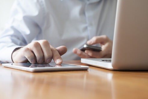 Männerhand beim Tippen auf dem Touchscreen eines digitalen Tablets - RBF002447