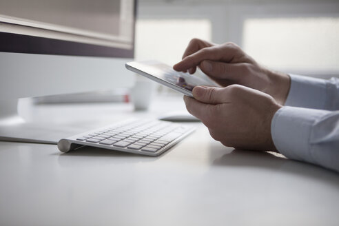 Männerhand beim Tippen auf dem Touchscreen eines digitalen Tablets - RBF002450