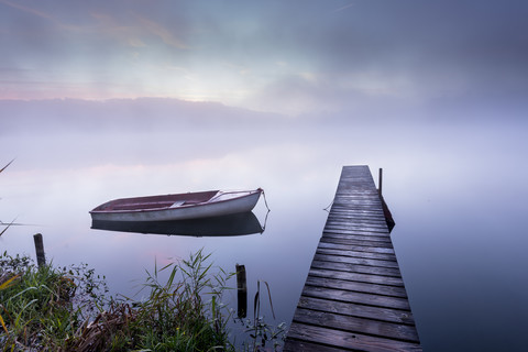 Deutschland, Wessling, Wesslinger See, Boot und Holzpromenade im Morgennebel, lizenzfreies Stockfoto