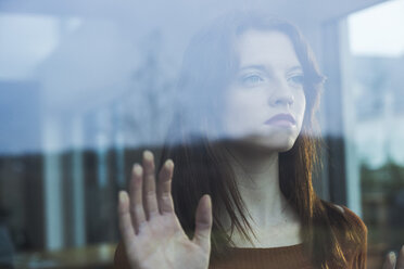 Serious young woman behind windowpane - UUF003222