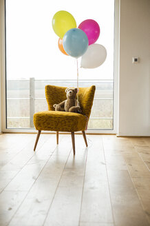 Ein Haufen Luftballons, ein Teddybär und ein Stuhl am Fenster - UUF003305