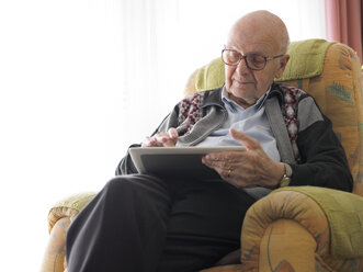 Alter Mann zu Hause mit digitalem Tablet - LAF001299