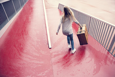 Austria, Thalgau, teenage girl with suitcase running down a ramp - WWF003766