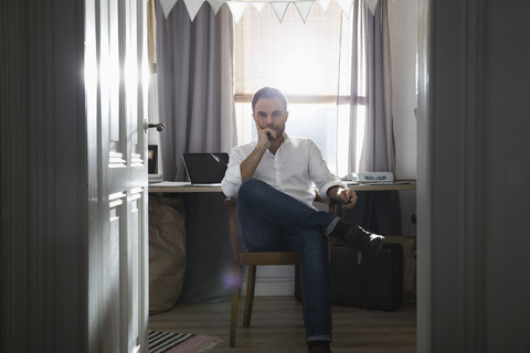 Nachdenklicher Mann in seinem Heimbüro, lizenzfreies Stockfoto