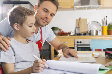Vater hilft seinem Sohn bei den Hausaufgaben - PDF000686