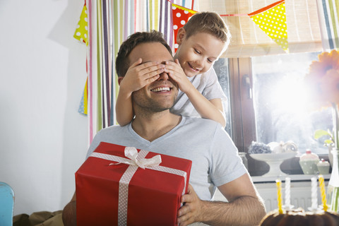 Sohn überrascht seinen Vater mit Geburtstagsgeschenk, lizenzfreies Stockfoto