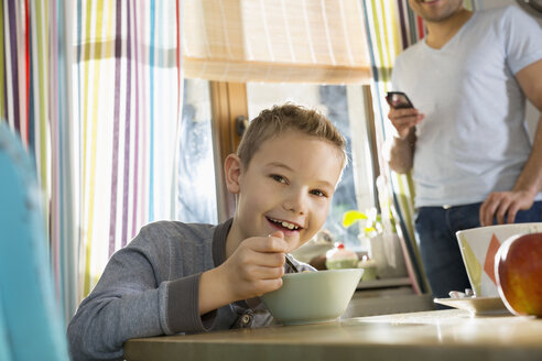 Portrait of smiling boy sitting at breakfast table with granola - PDF000744