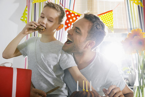 Vater und Sohn essen Geburtstagskuchen, lizenzfreies Stockfoto