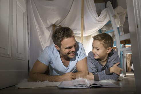 Vater und Sohn haben Spaß in einem selbstgebauten Zelt zu Hause - PDF000722