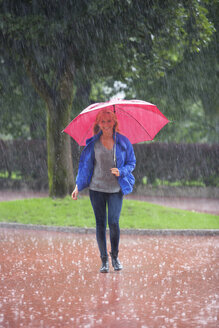 Österreich, Thalgau, junges Mädchen mit rotem Regenschirm im Regen - WWF003774