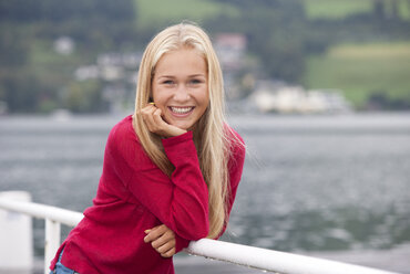 Österreich, Mondsee, Porträt eines lächelnden Teenagers mit rotem Pullover - WWF003782