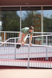 Junger Mann springt über Geländer - WWF003708