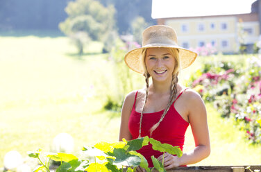 Porträt eines lächelnden Teenager-Mädchens bei der Gartenarbeit - WWF003811