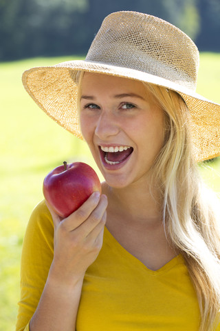 Portrait of smiling teenage girl eating an apple stock photo