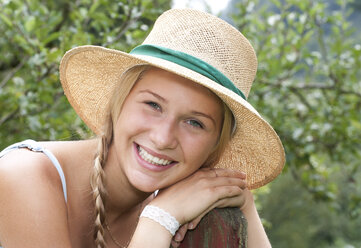 Portrait of smiling teenage girl wearing straw hat - WWF003826