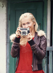 Portrait of smiling teenage girl with old camera - WWF003801