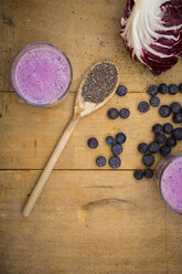 Two glasses of blueberry radicchio smoothie and wooden spoon with chia seeds - LVF002758