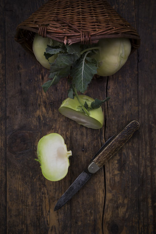 Geschnittene und ganze Kohlrabi und Taschenmesser auf Holz, lizenzfreies Stockfoto