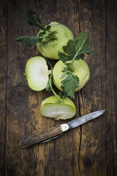 Sliced and whole kohlrabies and pocket knife on wood - LVF002776