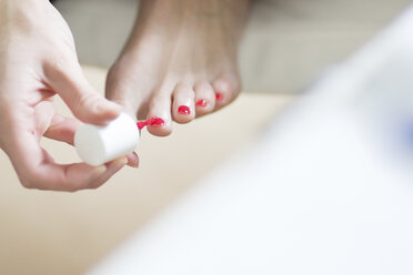 Woman painting her toenails pink - CHPF000042