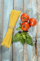 Spaghetti, Basilikum und Tomaten auf Holz - MAEF009693
