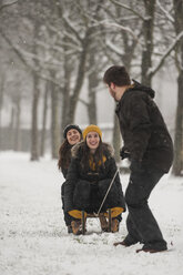 Drei Freunde haben Spaß mit dem Schlitten im Winter - PAF001248