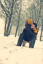 Young couple in love on a sledge in winter - PAF001254