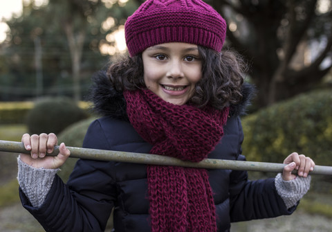 Porträt eines lächelnden kleinen Mädchens mit Wollmütze und Schal, lizenzfreies Stockfoto