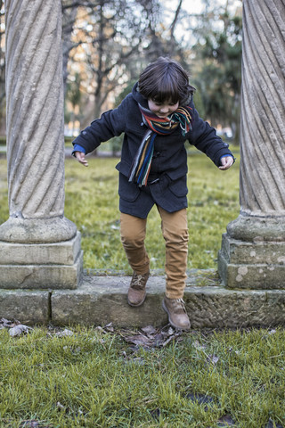 Little boy having fun in a park on a winter day stock photo