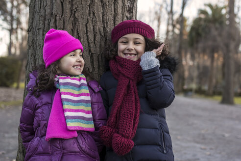 Zwei lächelnde kleine Mädchen in einem Park an einem Wintertag - MGOF000064