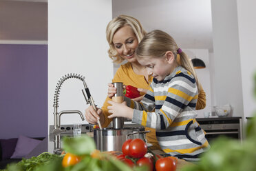 Mother and daughter cooking in kitchen - RBF002390