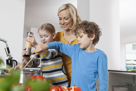 Mutter, Tochter und Sohn kochen in der Küche, lizenzfreies Stockfoto