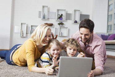 Glückliche Familie benutzt Laptop zu Hause - RBF002405