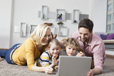 Happy family using laptop at home - RBF002405