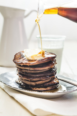 Ahornsirup auf Pfannkuchen gießen, lizenzfreies Stockfoto