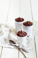 Three cups of vegan mousse au chocolat, tea spoons, cloth on white wood - SBDF001595