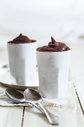 Zwei Tassen vegane Mousse au Chocolat, Teelöffel, Stoff auf weißem Holz - SBDF001602