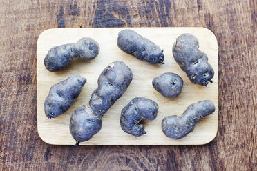 Purple potatoes on a cutting board - HAWF000614