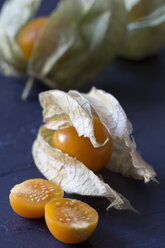 Ganze und in Scheiben geschnittene Physalis auf Schiefer - YFF000316