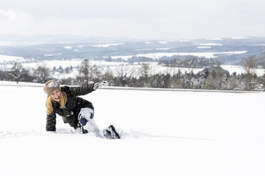Germany, Baden-Wuerttemberg, Waldshut-Tiengen, playful woman in snow - MIDF000051