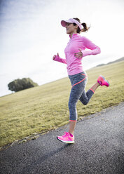 Spanien, Gijon, sportliche junge Frau, die auf einem Weg läuft - MGOF000073