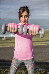 Spain, Gijon, sportive young woman doing workouts at the coast - MGOF000076