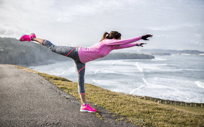 Spain, Gijon, sportive young woman exercising at the coast - MGOF000090