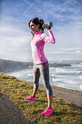 Spain, Gijon, sportive young woman doing workouts at the coast - MGOF000091