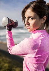 Spanien, Gijon, sportliche junge Frau beim Workout an der Küste - MGOF000093