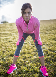 Spain, Gijon, sportive young woman standing on meadow - MGOF000097