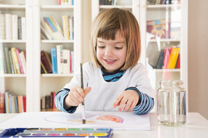 Portrait of smiling little girl painting with watercolours - LVF002809