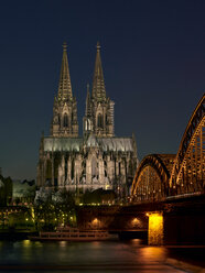 Deutschland, Köln, beleuchteter Kölner Dom und Hohenzollernbrücke bei Nacht - MAD000136