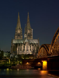 Deutschland, Köln, beleuchteter Kölner Dom und Hohenzollernbrücke bei Nacht - MAD000136